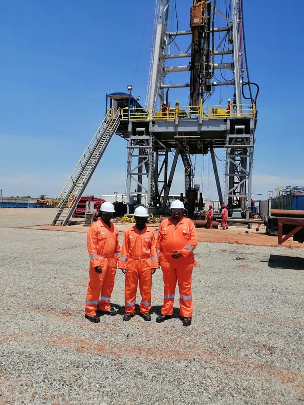 GGSL crew standing in front of a land rig on a prepared location